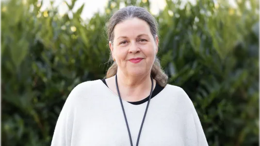 Stefanie Gertz steht vor grüner Hecke