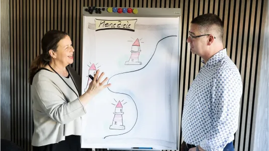 Stefanie Gertz steht am Flipchart mit einem Mann